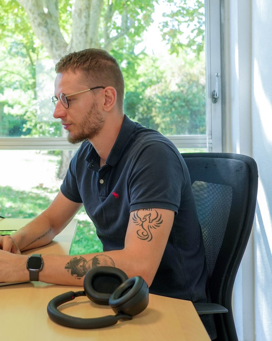 Brice Schwartz, lunettes sur le nez, en train d’écrire à son bureau